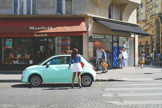 Woman in high street opening Fiat 500 car door