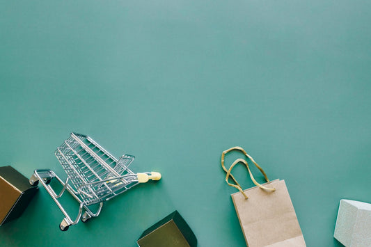Shopping cart, cream paper bag on teal background